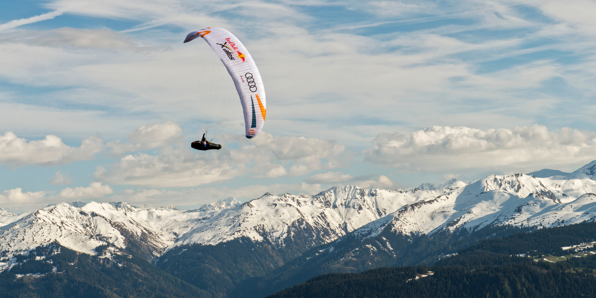 Während dem Red Bull X-Alps 2023 Rennen ist ein Gleitschirmflieger über den Alpen zu sehen.