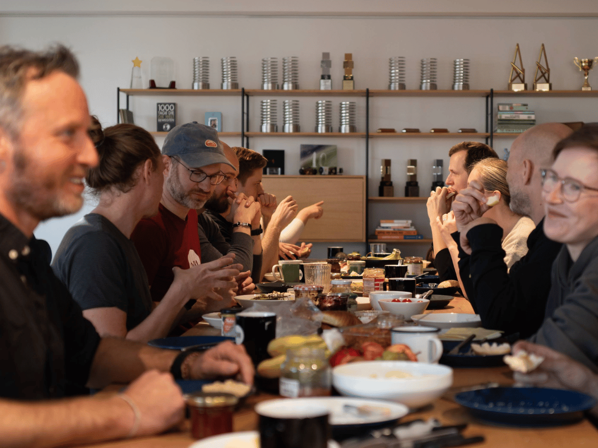 Das Team von Ubilabs sitzt gemeinsam beim Frühstück im Hamburger Büro